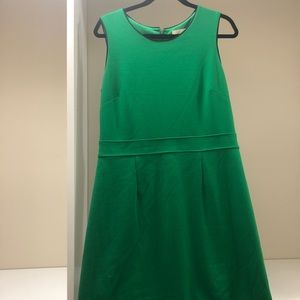 Green sleeveless dress with navy piping around the neck and shoulders